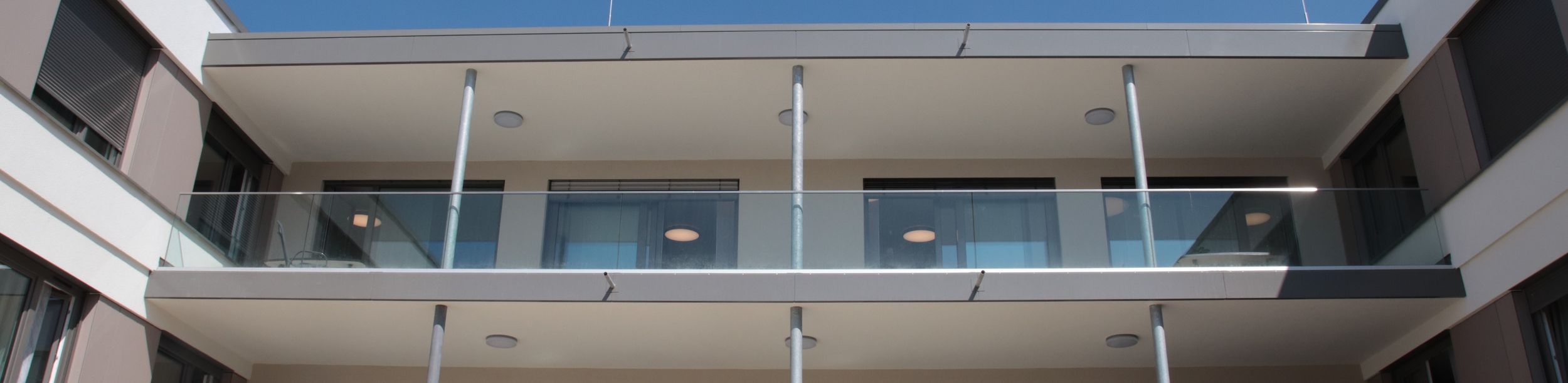 Fassadenansicht moderner Balkone mit Glasgeländern und Metallstützen