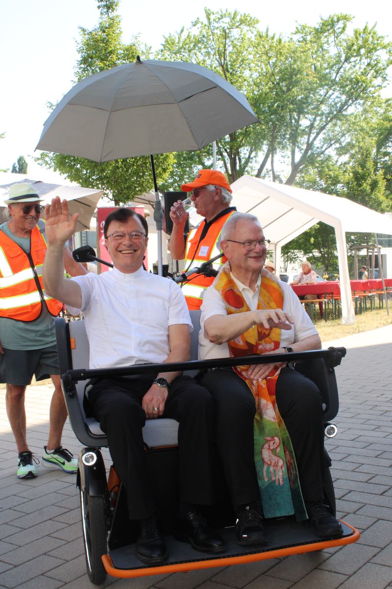 Zwei lächelnde Männer in Elektrokutsche beim Sommerfest des Fördervereins St. Vinzenz