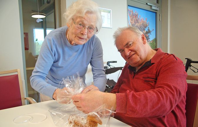 Seniorin und Senior verpacken Gebäck für Ostern