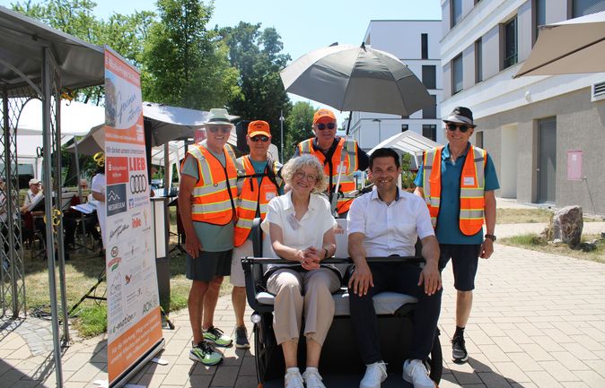 Gruppe mit Warnwesten und zwei sitzenden Gästen beim Sommerfest zum 30-jährigen Jubiläum