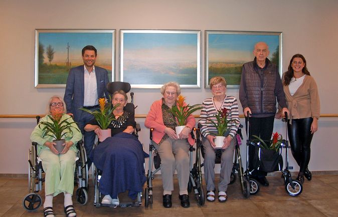 Gruppe von Bewohnern und Betreuenden mit Pflanzen nach Neuwahl