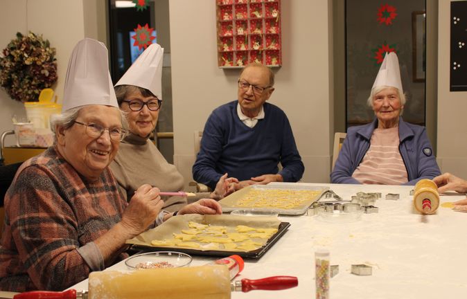 Seniorinnen und Senioren beim Plätzchenbacken mit Ausstechformen